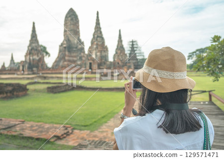 Wat Chaiwatthanaram temple, Ayutthaya historical park, Ayutthaya, Thailand Tourist photographing ancient temple ruins Wat Chaiwatthanaram temple, Ayutthaya historical park, Ayutthaya, Thailand Tourist photographing ancient temple ruins 129571471