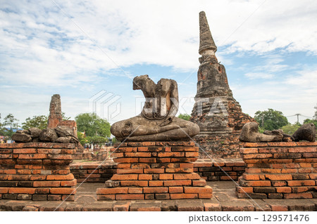Wat Chaiwatthanaram temple, Ayutthaya historical park, Ayutthaya, Thailand Ancient temple ruins with a Buddha statue Wat Chaiwatthanaram temple, Ayutthaya historical park, Ayutthaya, Thailand Ancient temple ruins with a Buddha statue 129571476