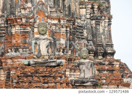 Wat Chaiwatthanaram temple, Ayutthaya historical park, Ayutthaya, Thailand Ancient Buddha statues on weathered temple structure 129571486