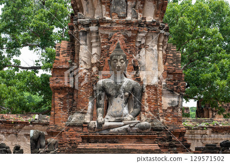 Wat Maha That, Ayutthaya, Thailand Ancient Buddha statue among ruins and greenery 129571502