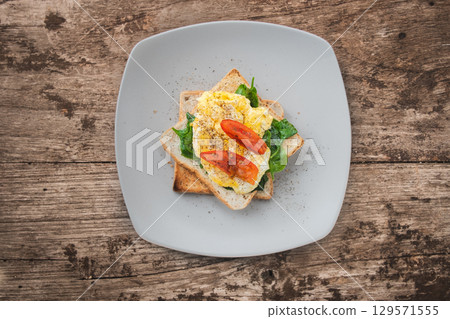 Breakfast sandwich with egg, watercress and tomato on the wooden table, healthy food 129571555
