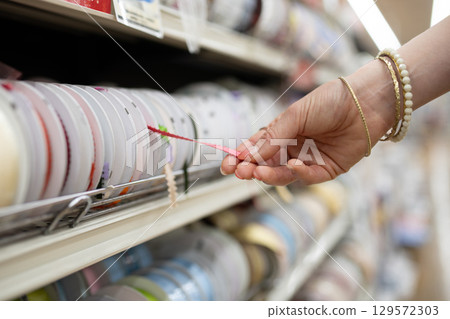 A woman's hands choosing a ribbon A woman's hands choosing a ribbon 129572303