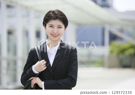 Young businesswoman standing with a smile in the business district 129572338