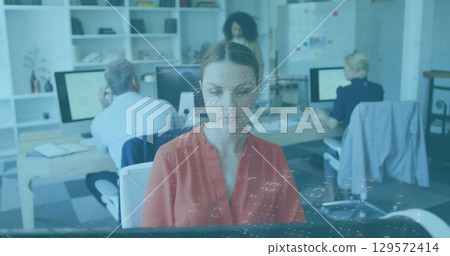 Image of data processing against caucasian woman using computer at office Image of data processing against caucasian woman using computer at office 129572414