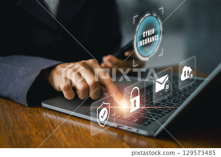 A business professional explores cyber insurance options on a laptop, highlighting digital security and protection. A business professional explores cyber insurance options on a laptop, highlighting digital security and protection. 129573485