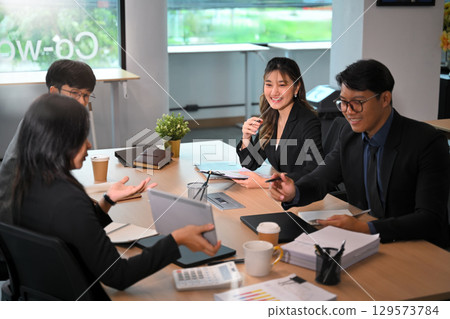 Group of business professionals in a team meeting discussing ideas and projects in an office Group of business professionals in a team meeting discussing ideas and projects in an office 129573784