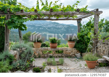 Wooden pergola covering a terrace with flower pots and offering a beautiful view of the valley 129574387