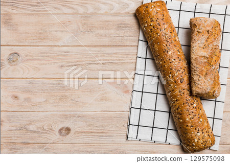 fresh crunchy french baguette on colored table. Top view Bakery products fresh crunchy french baguette on colored table. Top view Bakery products 129575098