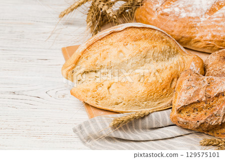 Homemade natural breads. Different kinds of fresh bread as background, perspective view with copy space 129575101