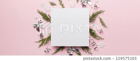 Flat lay Christmas composition. square Paper blank, pine tree branches, christmas decorations on Colored background. Top view, copy space for text 129575103