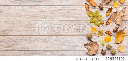 Autumn composition. Pattern made of dried leaves and other design accessories on table. Flat lay, top view 129575132