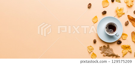 Flat lay composition with colorful Autumn cup of coffee and leaves on a color background. top view 129575209