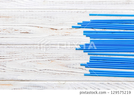 Heap of colorful plastic drinking straws on Colored background, flat lay. Copy Space for text 129575219