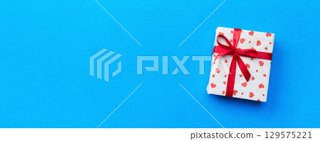 Gift box with red hearts on blue background. top view with copy space 129575221