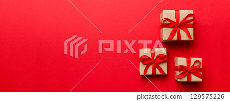 Valentine day composition: red gift box with bow and heart. Christmas present. View from above. Space for text. Holday greeting card 129575226