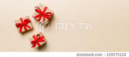 Valentine day composition: red gift box with bow and heart. Christmas present. View from above. Space for text. Holday greeting card Valentine day composition: red gift box with bow and heart. Christmas present. View from above. Space for text. Holday greeting card 129575228