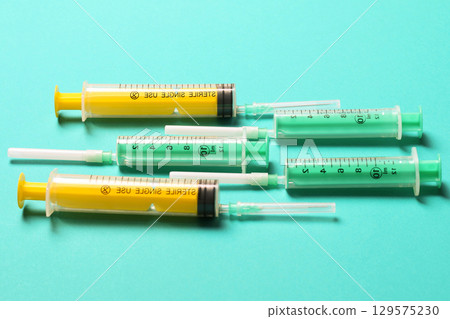 Top view of medical syringes with needles at blue background with copy space. Injection treatment concept Top view of medical syringes with needles at blue background with copy space. Injection treatment concept 129575230