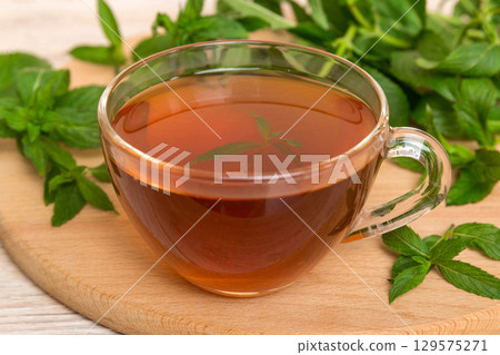 Cup of mint tea on table background. Green tea with fresh mint top view with copy space 129575271