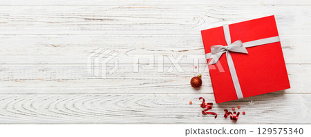 Top view Flat lay Christmas decorations and gift box on colored background with copy space. Christmas or Happy New Year composition Top view Flat lay Christmas decorations and gift box on colored background with copy space. Christmas or Happy New Year composition 129575340