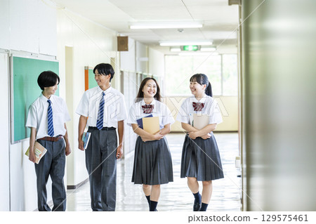 Male and female high school students walking down the school corridor Male and female high school students walking down the school corridor 129575461