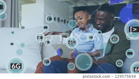 Image of icons and 6g over happy african american father and son using tablet Image of icons and 6g over happy african american father and son using tablet 129575639
