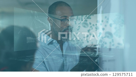 Image of blood cells, helix dna over senior african american man explaining and writing on board Image of blood cells, helix dna over senior african american man explaining and writing on board 129575711