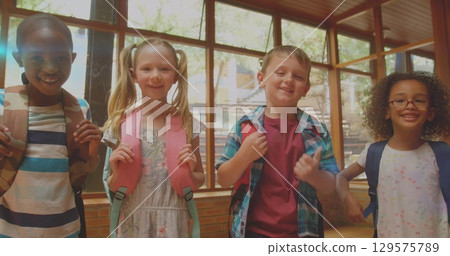 Image of glowing light over smiling diverse school children in classroom 129575789