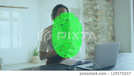 Image of biometric fingerprint scanner over caucasian having a imagecall on laptop at home 129575837