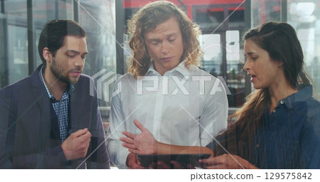 Image of data processing over diverse colleagues discussing over digital tablet at office Image of data processing over diverse colleagues discussing over digital tablet at office 129575842