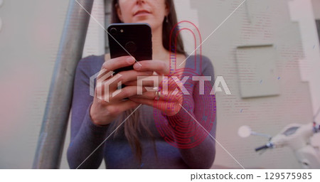 Image of security padlock icon over caucasian woman using smartphone outdoors 129575985