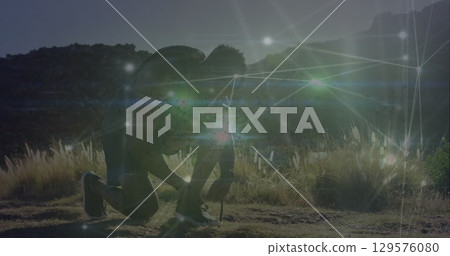 Image of glowing network of connections over african american fit man tying shoe laces outdoors 129576080