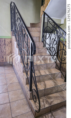 Stone steps and forged railings. Staircase to the second floor in the house. 129576275