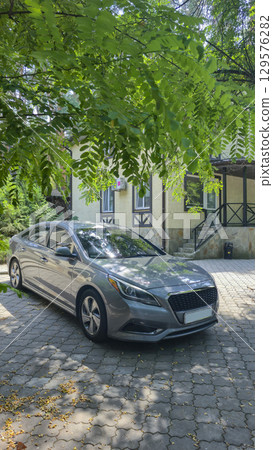 Car parked near the house. Tourist recreation. Park area. Summer nature. Vehicle 129576282