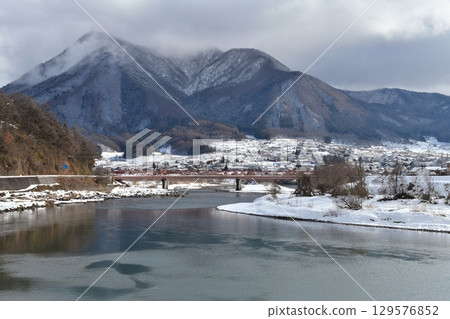 On a clear day in January 3rd, in Iiyama City, Nagano Prefecture, the Chikuma River and the red Komaki Bridge were captured on camera with Mount Takayashiro shrouded in snow clouds in the background. On a clear day in January 3rd, in Iiyama City, Nagano Prefecture, the Chikuma River and the red Komaki Bridge were captured on camera with Mount Takayashiro shrouded in snow clouds in the background. 129576852
