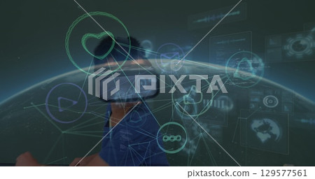 Image of connected icons, codes, globe over caucasian boy playing while using vr headset 129577561