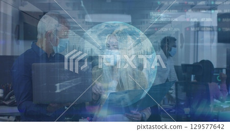 Image of globe and data over diverse coworkers in face masks in office 129577642