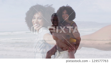 Image of happy african american couple piggybacking on beach over woman beckoning partner to sea Image of happy african american couple piggybacking on beach over woman beckoning partner to sea 129577763