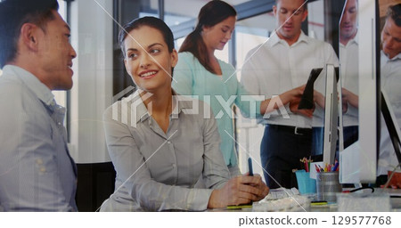 Image of graphs over diverse businesspeople working in office 129577768