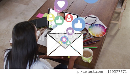 Image of email and social media icons over caucasian woman on laptop image call 129577771