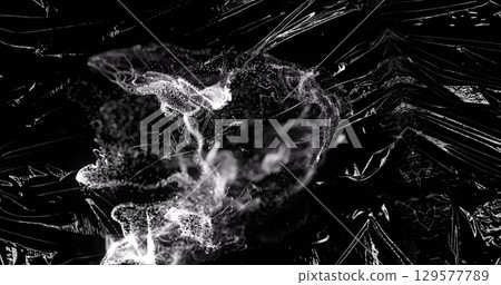 Image grey ring of smoke over light on moving shiny black plastic 129577789