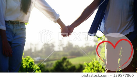 Image of heart icon over caucasian couple in love holding hands in park 129577860