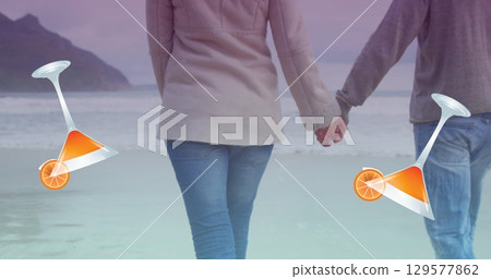 Image of cocktail glasses falling over caucasian couple in love holding hands by seaside 129577862