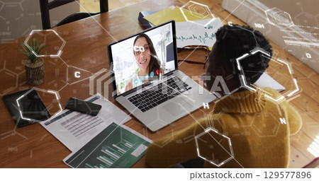 Image of chemical formulas over african american woman having image call on laptop 129577896