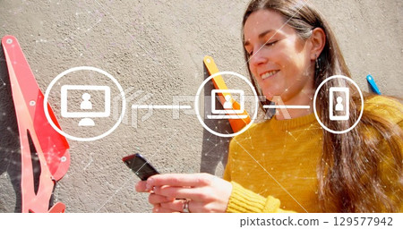 Image of network with digital icons over caucasian woman using smartphone Image of network with digital icons over caucasian woman using smartphone 129577942