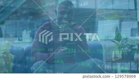 Image of financial data processing over african american businessman using smartphone 129578009