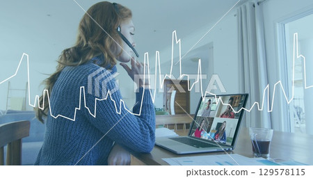 Image of graph over caucasian woman having a imagecall on laptop at home 129578115