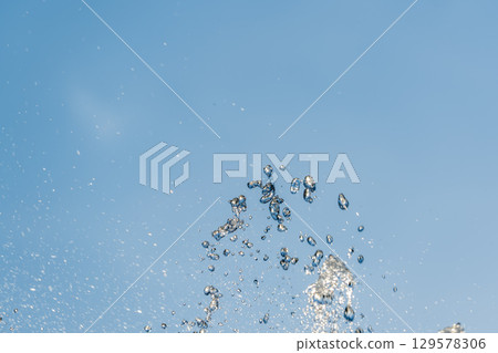 Splashes and jets of water against light background. 129578306