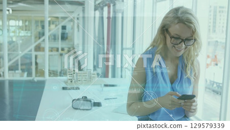 Image of data processing over caucasian woman using smartphone 129579339