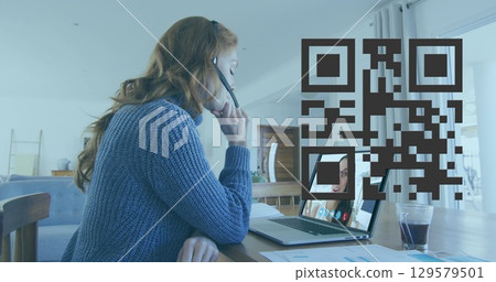 Image of qr code over caucasian woman having image call on laptop Image of qr code over caucasian woman having image call on laptop 129579501