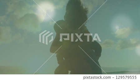 Image of light spots over couple at beach Image of light spots over couple at beach 129579555